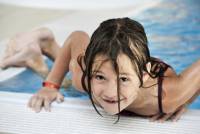 Kinderschwimmen Mädchen klettert aus dem Schwimmbecken